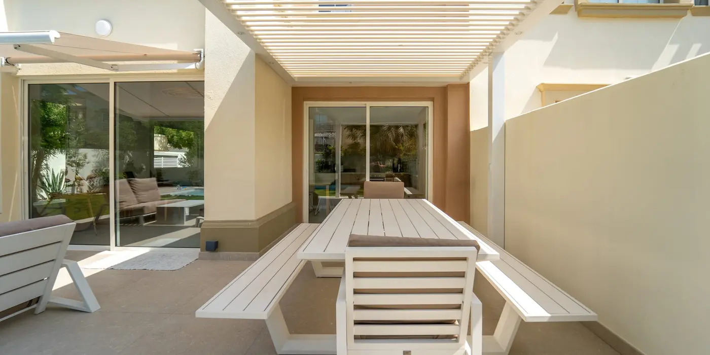 Wall-mounted Liwa pergola with spotlights over an outdoor dining table at a villa in The Springs, Dubai