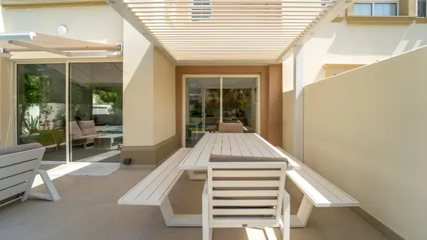 Wall-mounted Liwa pergola with spotlights over an outdoor dining table at a villa in The Springs, Dubai