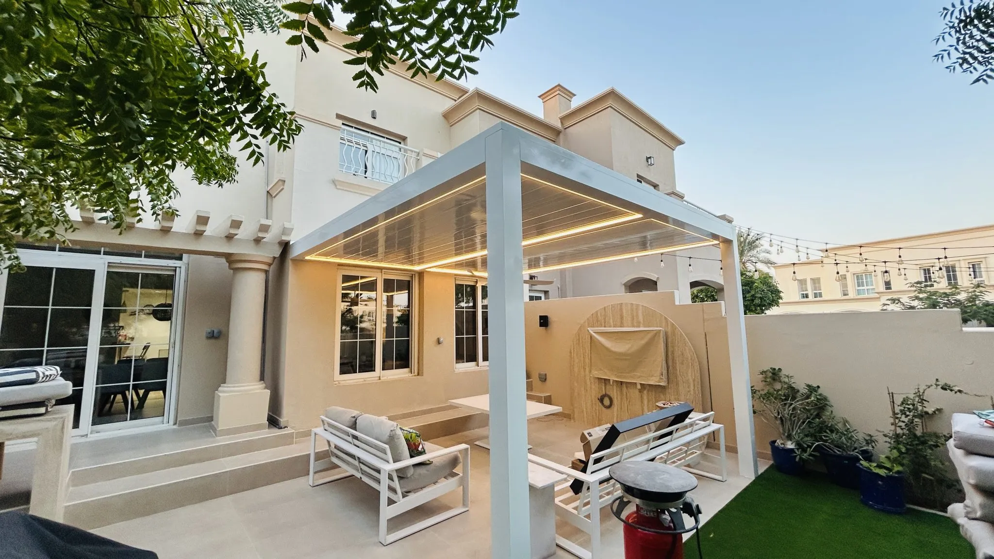White Nimbus waterproof pergola with LED lighting over a terrace in The Springs