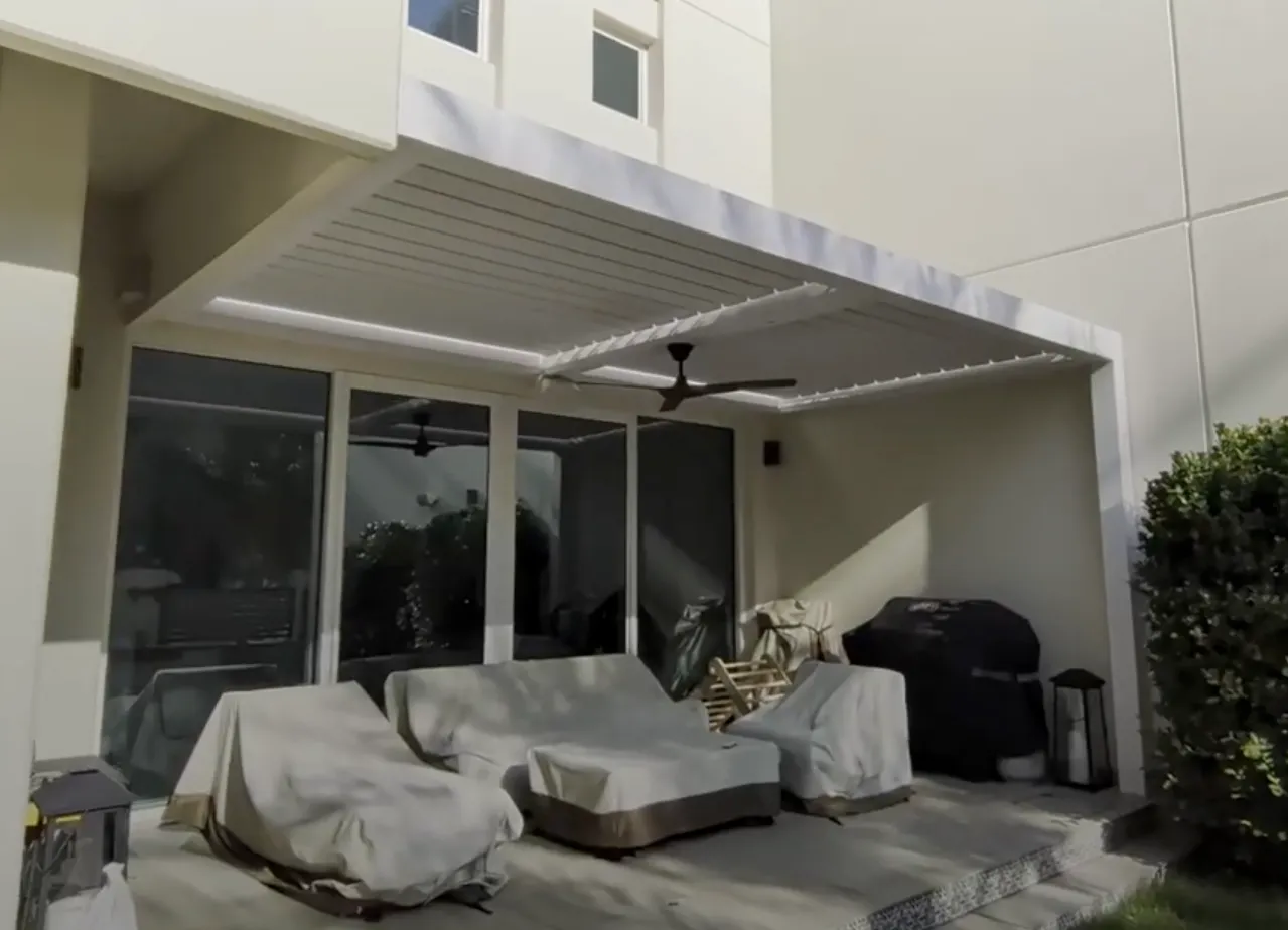 Wall-mounted Sierra pergola with a ceiling fan over a side terrace in The Sustainable City